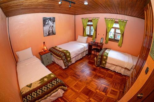 Cette petite chambre comprend deux lits et une table. dans l'établissement La Casa del Molino Blanco B&B, à Baños