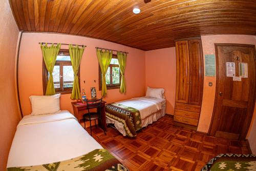 a small room with two beds and a table at La Casa del Molino Blanco B&B in Baños