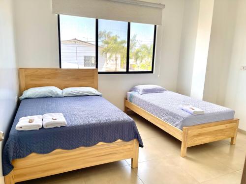 ein Schlafzimmer mit 2 Betten und Handtüchern darauf in der Unterkunft MARBONI in Salinas
