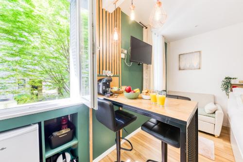 - une cuisine avec une table dans une chambre avec une fenêtre dans l'établissement Le Central Green Studio Parisien Cosy Proche Métro, à Clichy