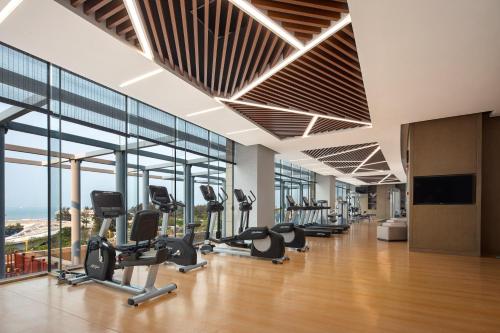 a gym with a row of treadmills and ellipticals at Crowne Plaza Beihai Silver Beach by IHG in Beihai