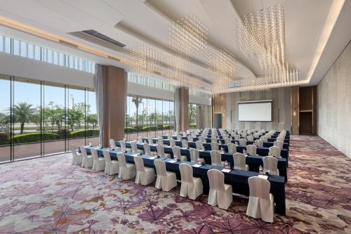 a large room with a lecture hall with chairs and a screen at Crowne Plaza Beihai Silver Beach by IHG in Beihai