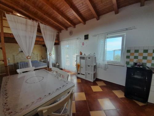 a kitchen with a table and a large window at Moja posebna kuća na osami kraj mora in Vis