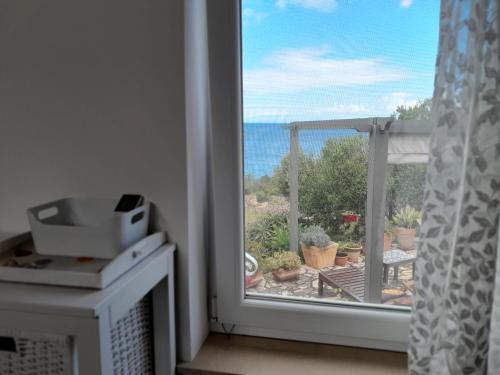 a room with a window with a view of the ocean at Moja posebna kuća na osami kraj mora in Vis