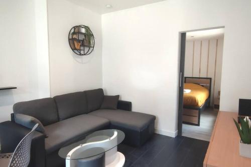 un salon avec un canapé et un lit dans l'établissement Charmant cocon au cœur de Reims, à Reims