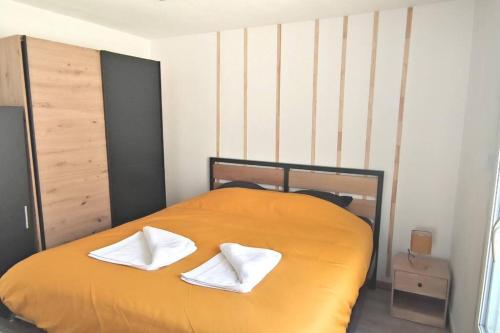 a bed with two white towels on top of it at Charmant cocon au cœur de Reims in Reims
