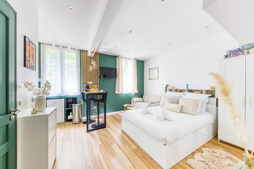 - un salon avec un canapé blanc et un bureau dans l'établissement Le Central Green Studio Parisien Cosy Proche Métro, à Clichy