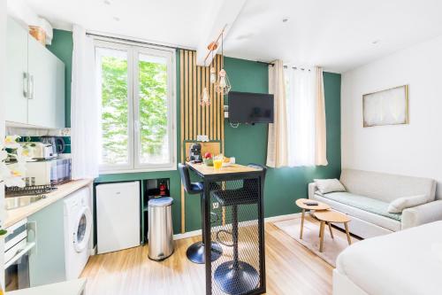 une petite cuisine et un salon avec des murs verts dans l'établissement Le Central Green Studio Parisien Cosy Proche Métro, à Clichy