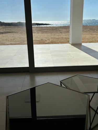 a room with a glass table and a view of the ocean at BEACH WHITE VILLAs in Minia