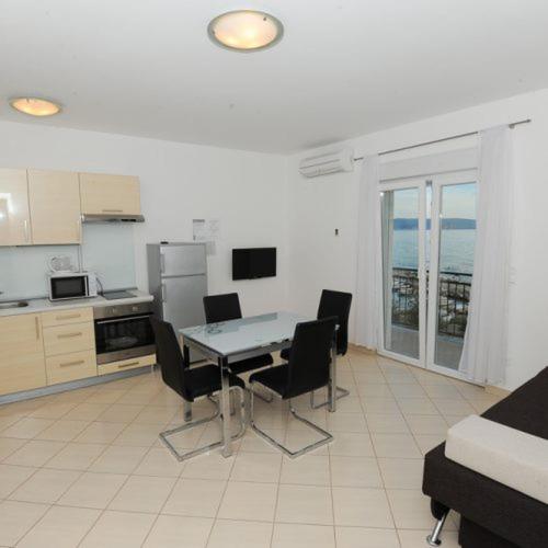 a kitchen with a table and chairs in a room at Apartmani Ivo in Podstrana