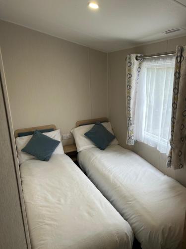 two beds in a small room with a window at Secluded spot on Southview 8 berth in Lincolnshire