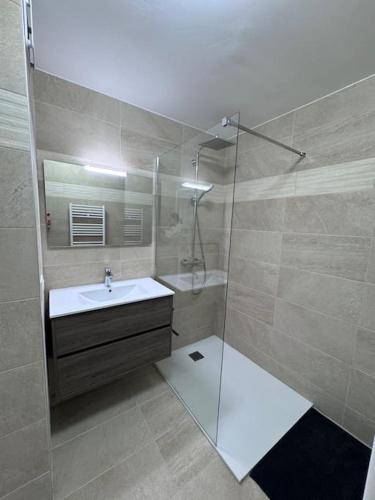 une salle de bain avec une douche en verre et un lavabo dans l'établissement Spacieux T2 - Grande terrasse, à Fréjus