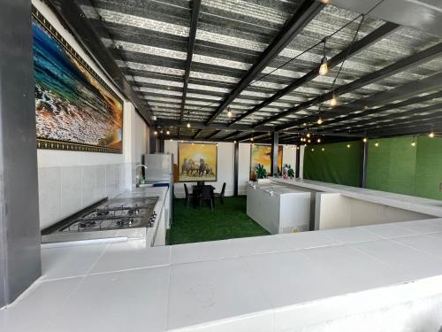 una cocina con electrodomésticos blancos y una pared verde en HOTEL AVICTORIA, en Tonsupa