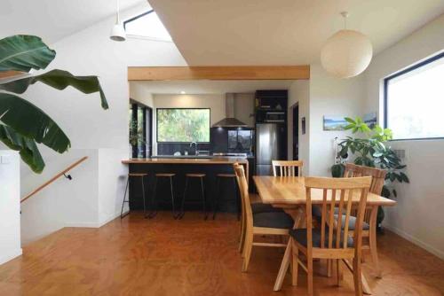 a kitchen and dining room with a wooden table and chairs at Beachside Family Surf Retreat in Carlton