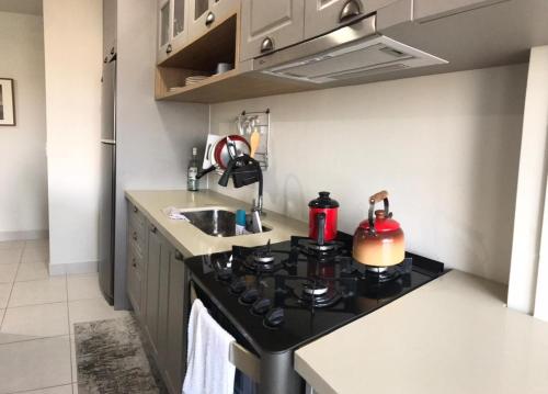 una pequeña cocina con fogones y fregadero en Aconchego em Criciúma/SC en Criciúma