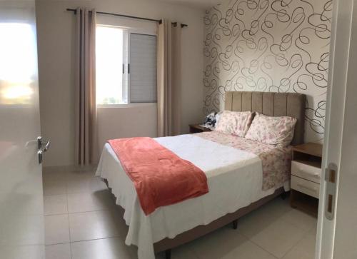 sypialnia z łóżkiem i oknem w obiekcie Aconchego em Criciúma/SC w mieście Criciúma