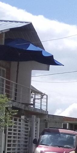 a purple car parked in front of a building with a blue umbrella at Mirador del lago in Calima