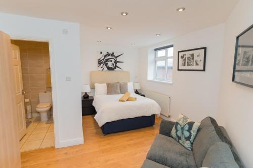 a living room with a bed and a couch at Birmingham City Apartments - spacious with free secure parking in Birmingham