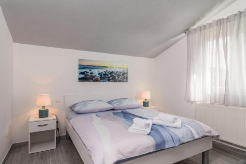 ein Schlafzimmer mit einem Bett mit zwei Handtüchern darauf in der Unterkunft Rooms Anna in Trogir