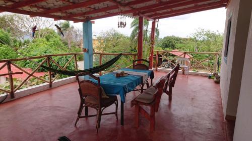 a table and chairs on a porch with a hammock at Palma Real 1 in Madama