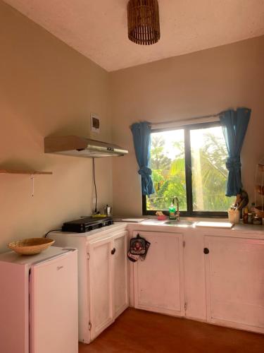 uma cozinha com armários brancos e uma janela em Palma Real 1 em Madama