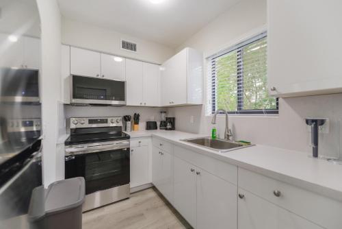 a white kitchen with a sink and a stove at Prime Location Apartment at Calle Ocho in Miami
