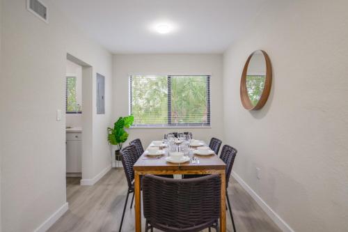 a dining room with a table with chairs and a mirror at Prime Location Apartment at Calle Ocho in Miami