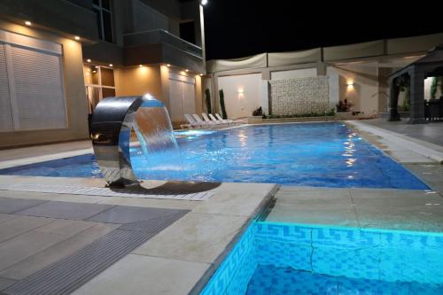 a swimming pool with a water slide in a building at Waves Chalet in Al Mazār