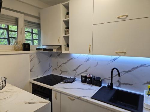 a kitchen with marble counter tops and a sink at Apartment Mia in Mostar