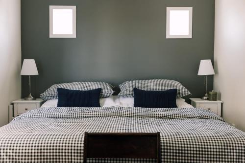 a bedroom with a large bed with blue pillows at County Escape on Corey in Bloomfield