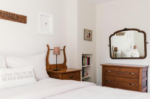 a bedroom with a bed with a mirror and a dresser at County Escape on Corey in Bloomfield