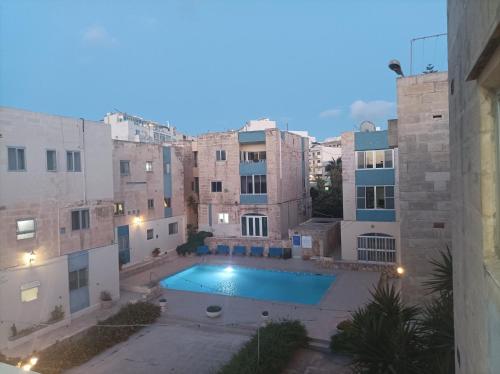 a view of a pool in a courtyard of a building at Beautiful flat with Swimming-pool & Seaview in St. Paul's Bay