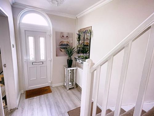 a white hallway with a white door and stairs at Entire 3 Bed Home in Oldham in Oldham