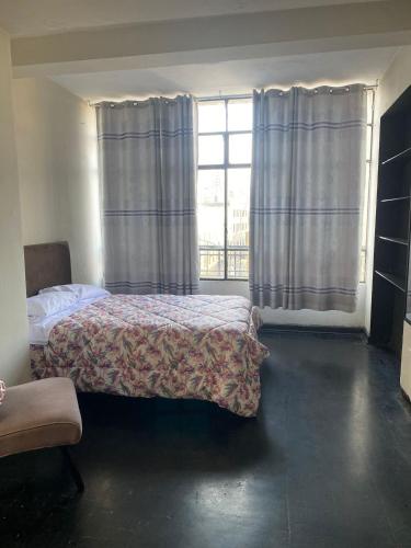 ein Schlafzimmer mit einem Bett und einem großen Fenster in der Unterkunft Habitación en Centro Histórico in Lima