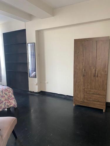 ein leeres Zimmer mit einem Holzschrank und einem Schlafzimmer in der Unterkunft Habitación en Centro Histórico in Lima