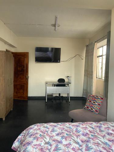 1 dormitorio con cama, mesa y TV en Habitación en Centro Histórico, en Lima