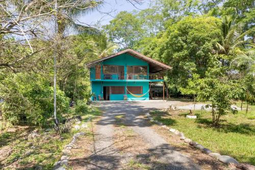 a blue house in the middle of a forest at Casa Patricia in Uvita
