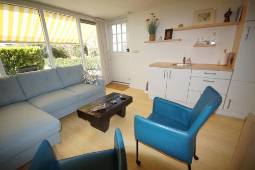 een woonkamer met een bank, stoelen en een tafel bij Marretoer in Uitwellingerga