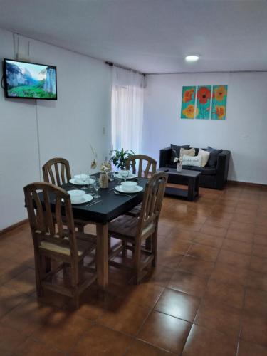 comedor con mesa, sillas y sofá en Hospedaje Isabelina en Las Heras