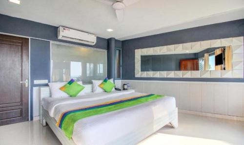 a bedroom with a large white bed with green pillows at Moon Bliss in Mandrem