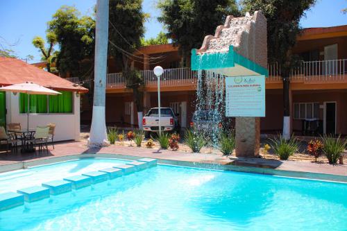 a swimming pool at a hotel with a water fountain at Hotel La Quinta Posada Real in Culiacán