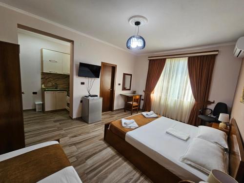 um quarto de hotel com uma cama grande e uma televisão em Apartment Koka em Berati