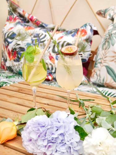 deux cocktails assis sur une table en bois avec des fleurs dans l'établissement Oasis Love, à Sens