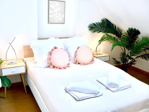 deux animaux en peluche roses assis sur un lit blanc dans l'établissement Oasis Love, à Sens