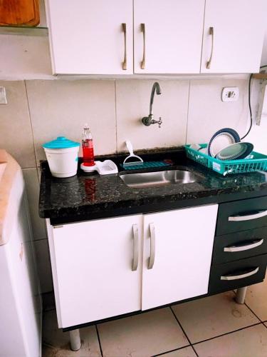 a kitchen with a sink and a counter top at Suítes Para Casal in Bertioga