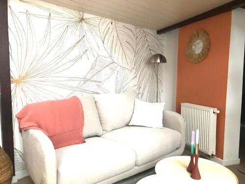 un salon avec un canapé blanc et une grande fenêtre dans l'établissement LE PETIT PRESBYTERE - HyperCentre - Rez de Chaussée - Thermes, à Vichy