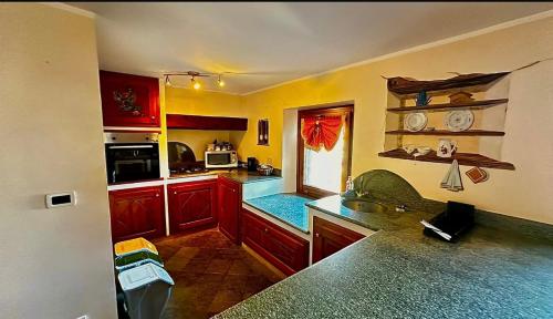 eine Küche mit roten Schränken und einer Arbeitsplatte in der Unterkunft Maison L’Abri in Introd