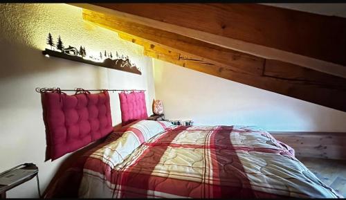 Schlafzimmer mit einem Bett mit Holzdecke in der Unterkunft Maison L’Abri in Introd