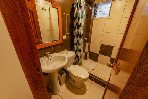 małą łazienkę z toaletą i umywalką w obiekcie Sacred Inka House w Machu Picchu