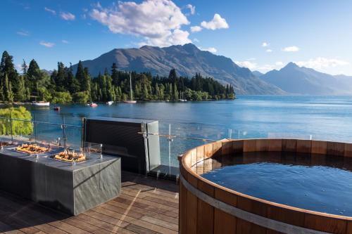 een hot tub op een terras met uitzicht op een meer bij Eichardt's Private Hotel in Queenstown